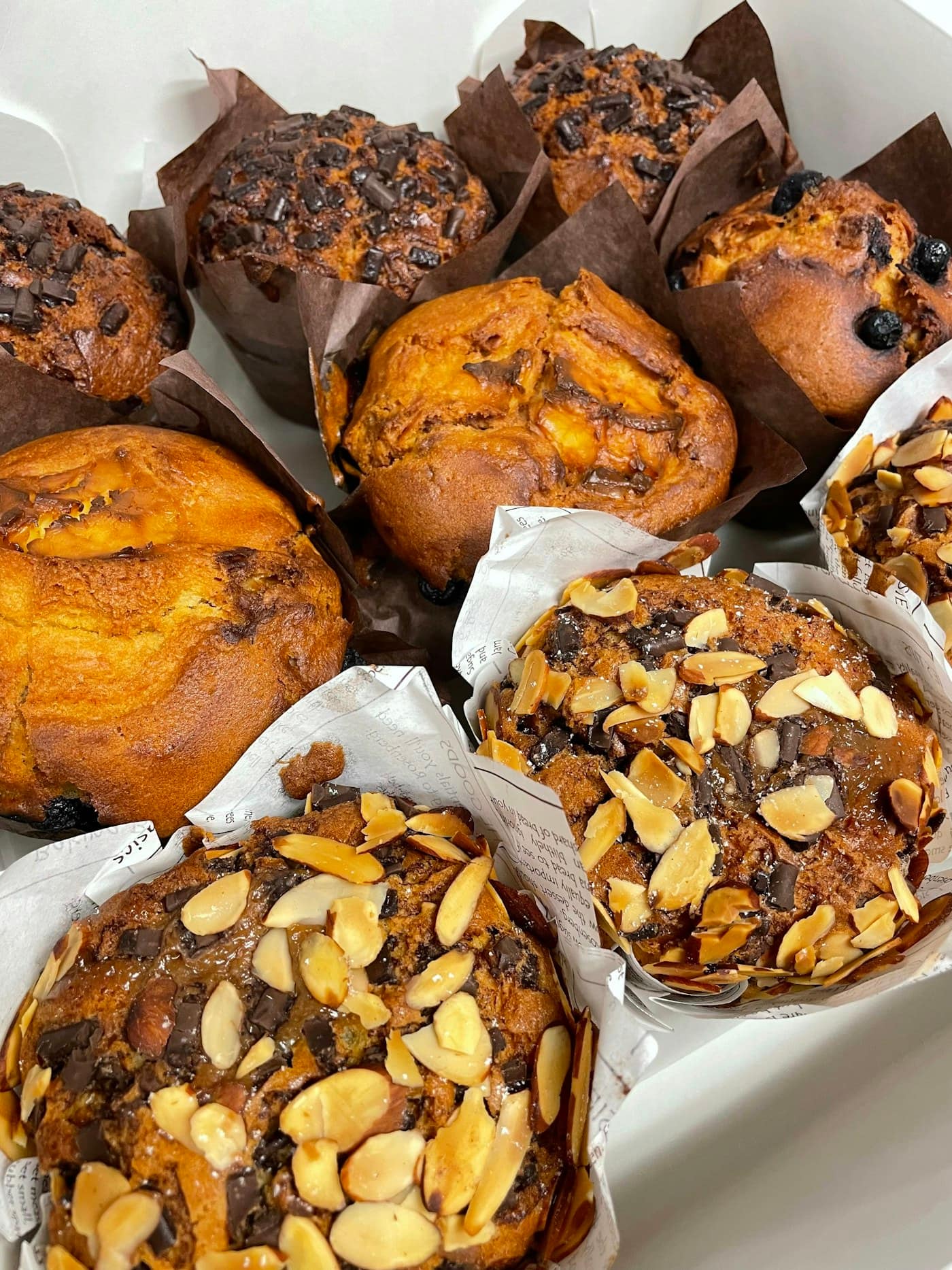Muffins in paper tulip cases packed close together in a box